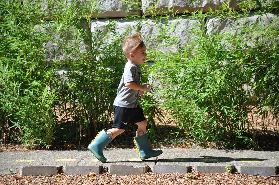 Child running around in rubber boots
